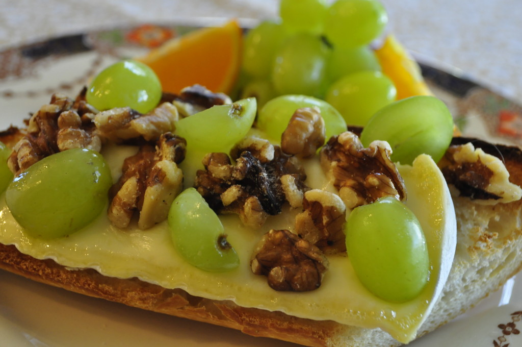 Place a slice of Fromager d'Affinois on a baguette and place it under the broiler just long enough to melt the cheese, then scatter grapes and walnuts over it.